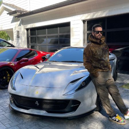 Scott Disick is sitting in his luxury car outside the garage.